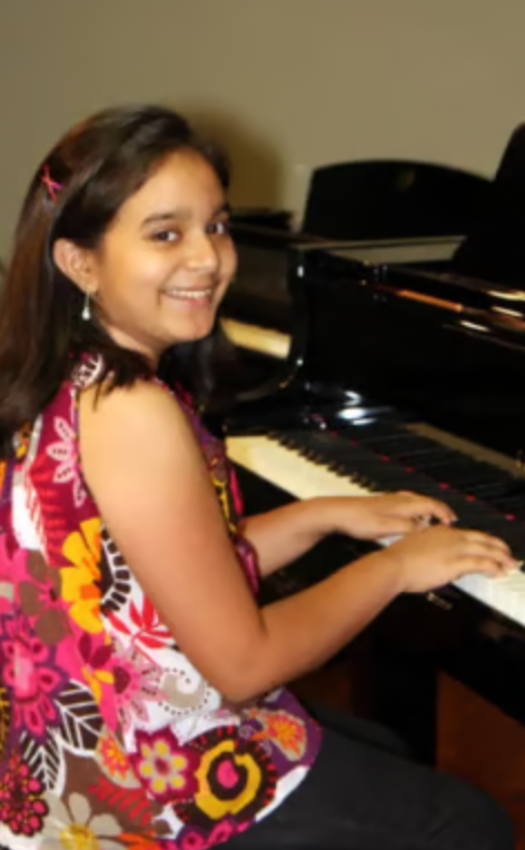 A smiling student at the piano